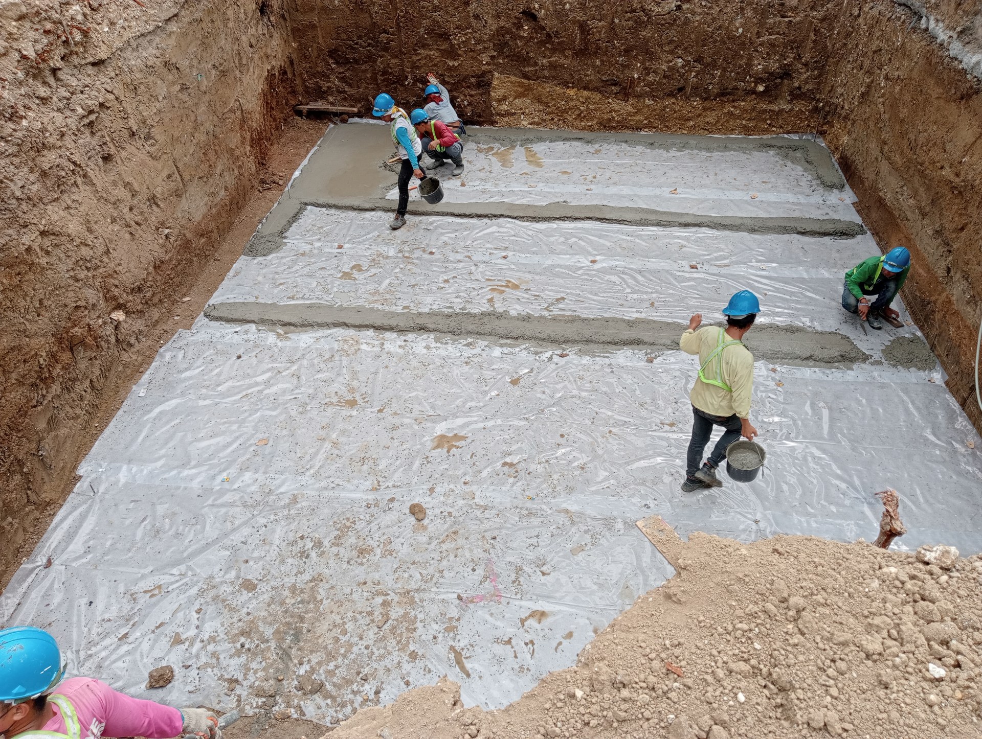 Concrete works at the tank excavation base.