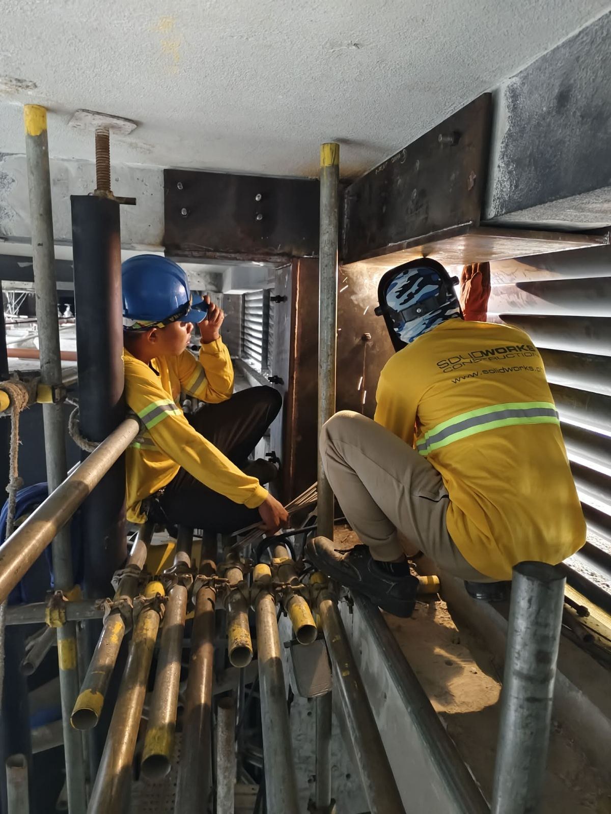 Crew working around the roof-column steel assembly.